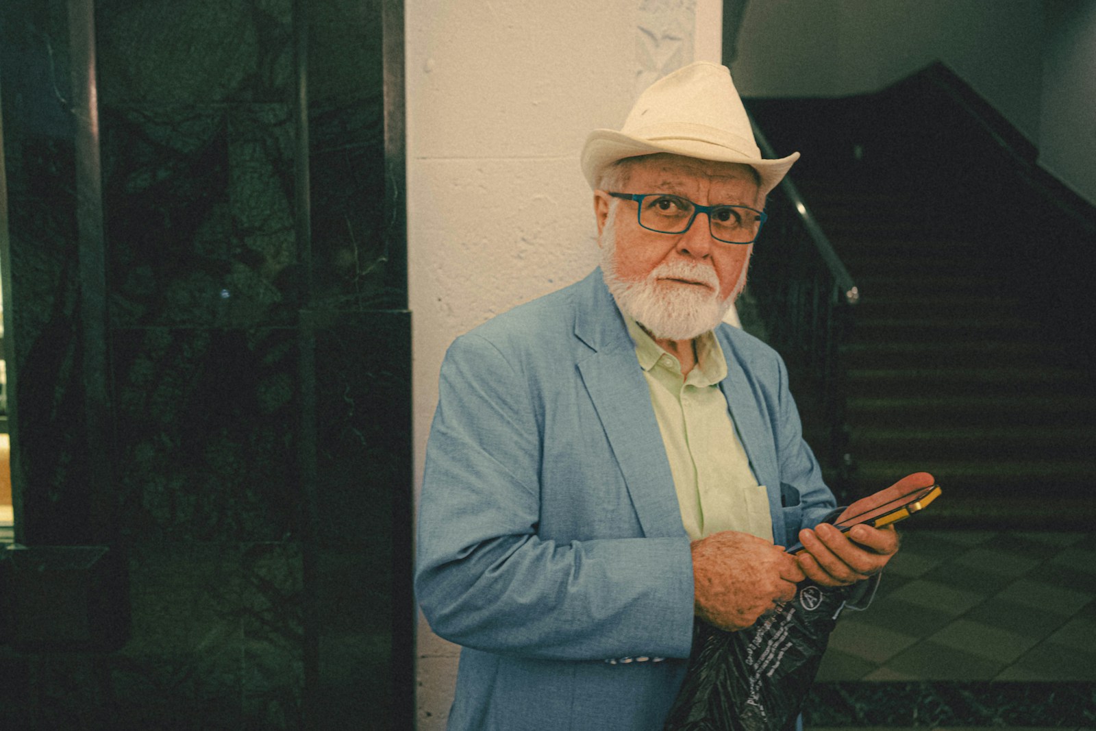 a man with a white beard wearing a blue suit and a white hat