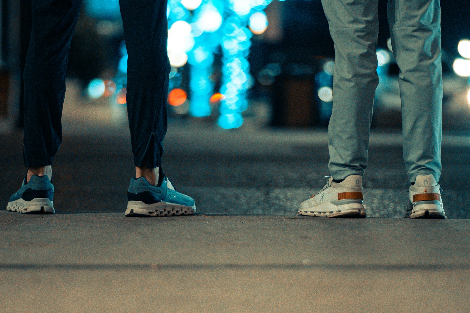 two people standing next to each other on a sidewalk