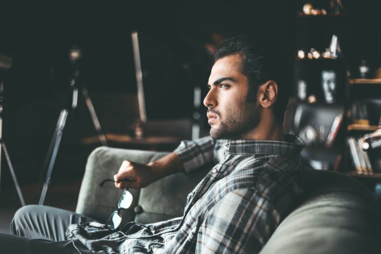man in black and white plaid dress shirt sitting on chair