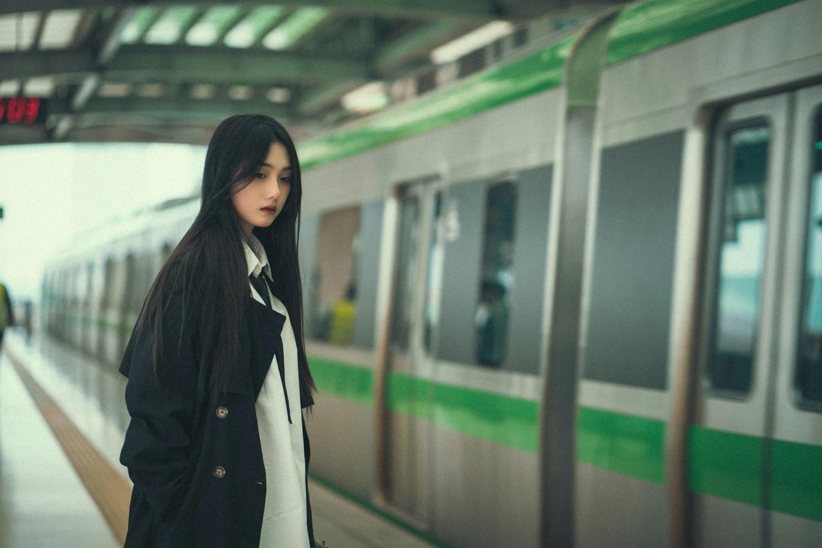 a woman standing in front of a train at a train station