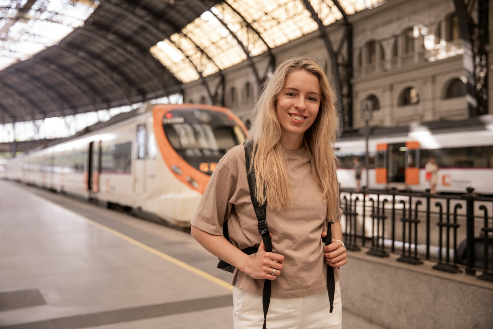 a woman standing in front of a train at a train station