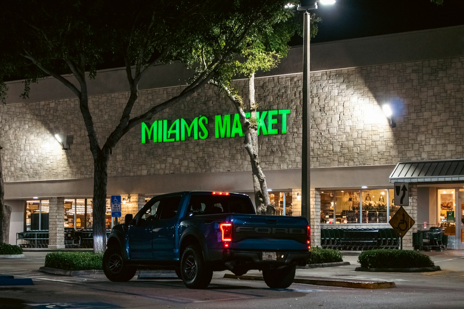 A truck parks outside milam's market at night.
