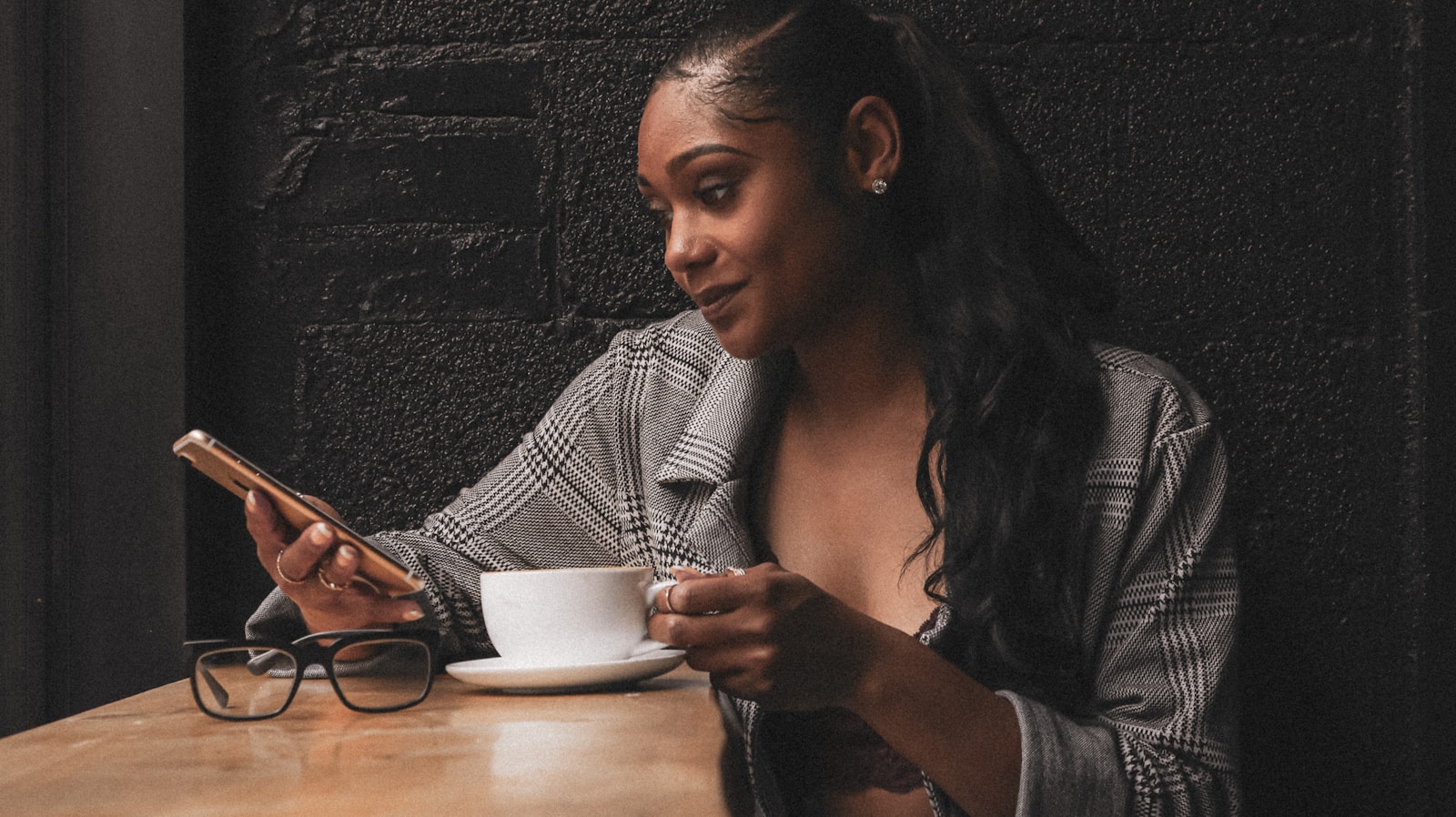 a woman sitting at a table looking at her cell phone