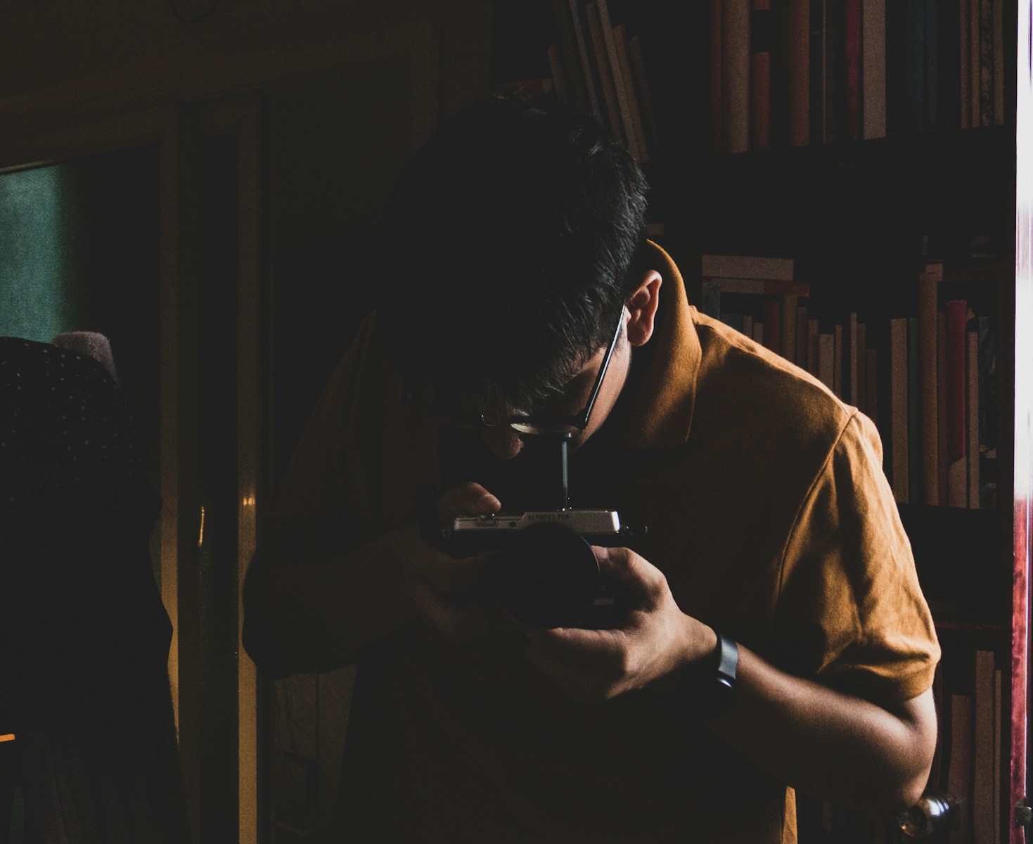 man in brown shirt holding smartphone