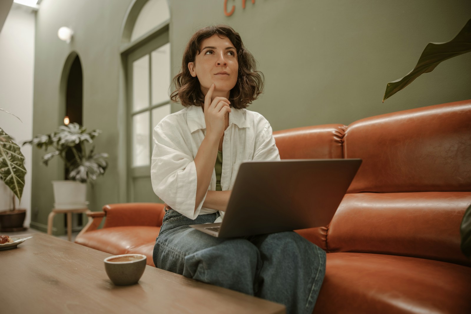 a woman sitting on a couch using a laptop computer