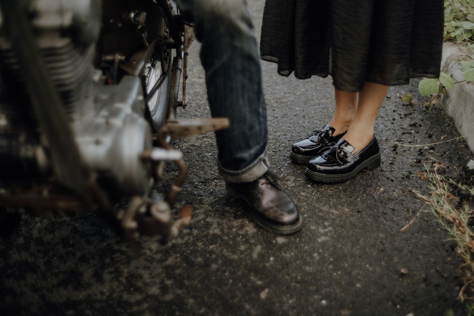 Close-up of a couple's shoes near a motorcycle on a street in Jakarta, Indonesia. Urban lifestyle concept.
