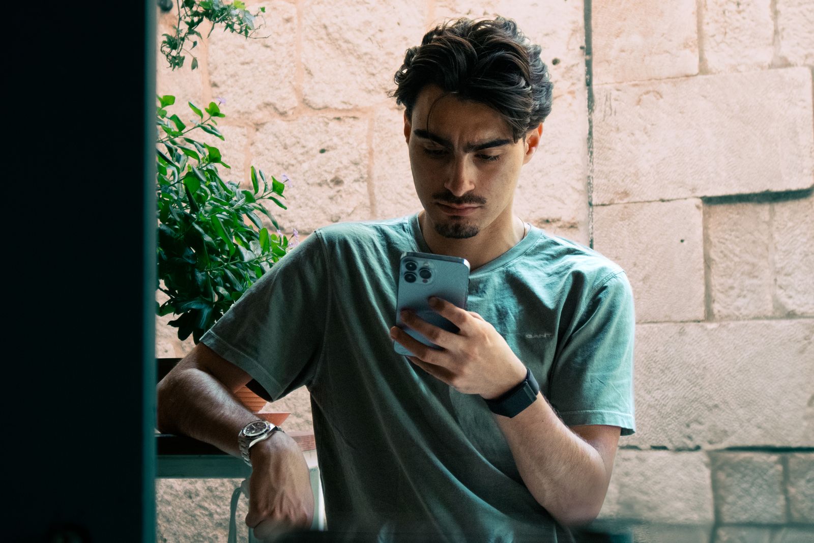 A young man in casual attire checking his phone outside in Split, Croatia.