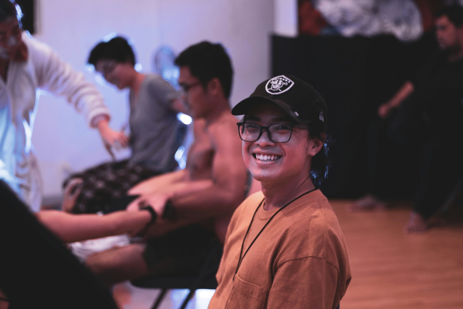 smiling woman in brown long sleeve shirt wearing black cap