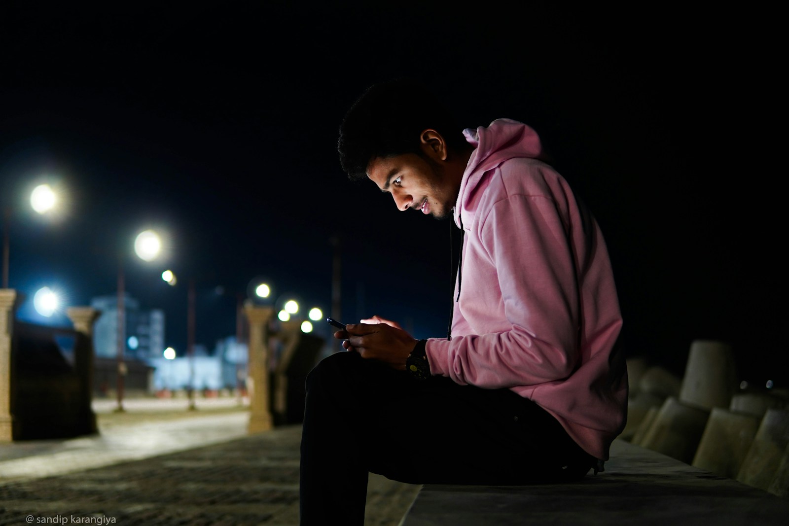 a man sitting on a bench looking at his cell phone