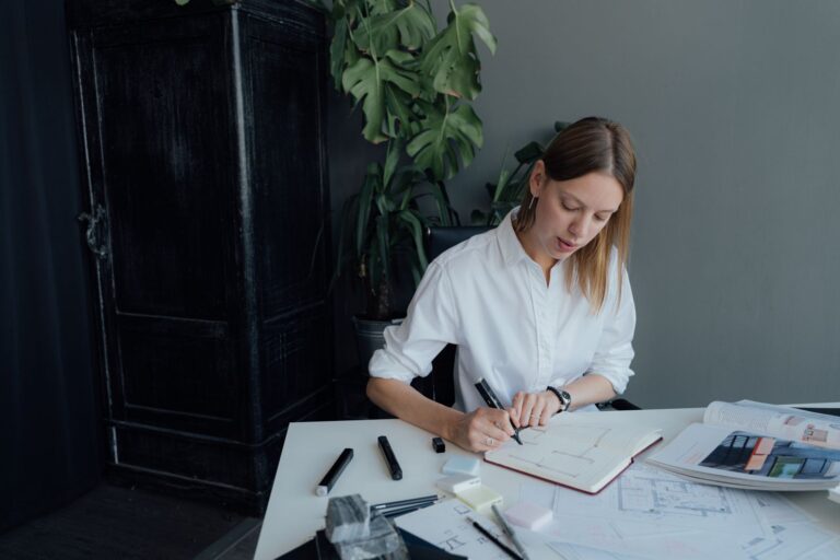 A young female architect working on floor plans at home, blending creativity and professionalism.