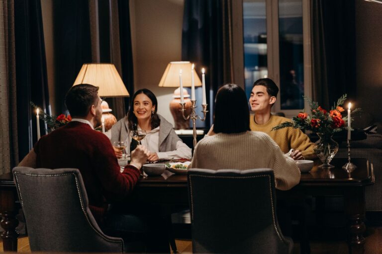 Warm indoor dinner scene with friends enjoying food and conversation.