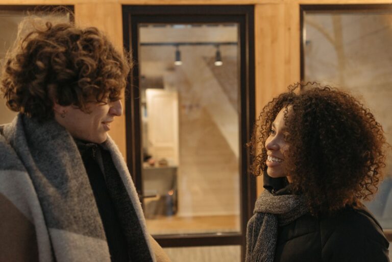 Casually dressed couple shares a joyful moment inside a cozy setting.