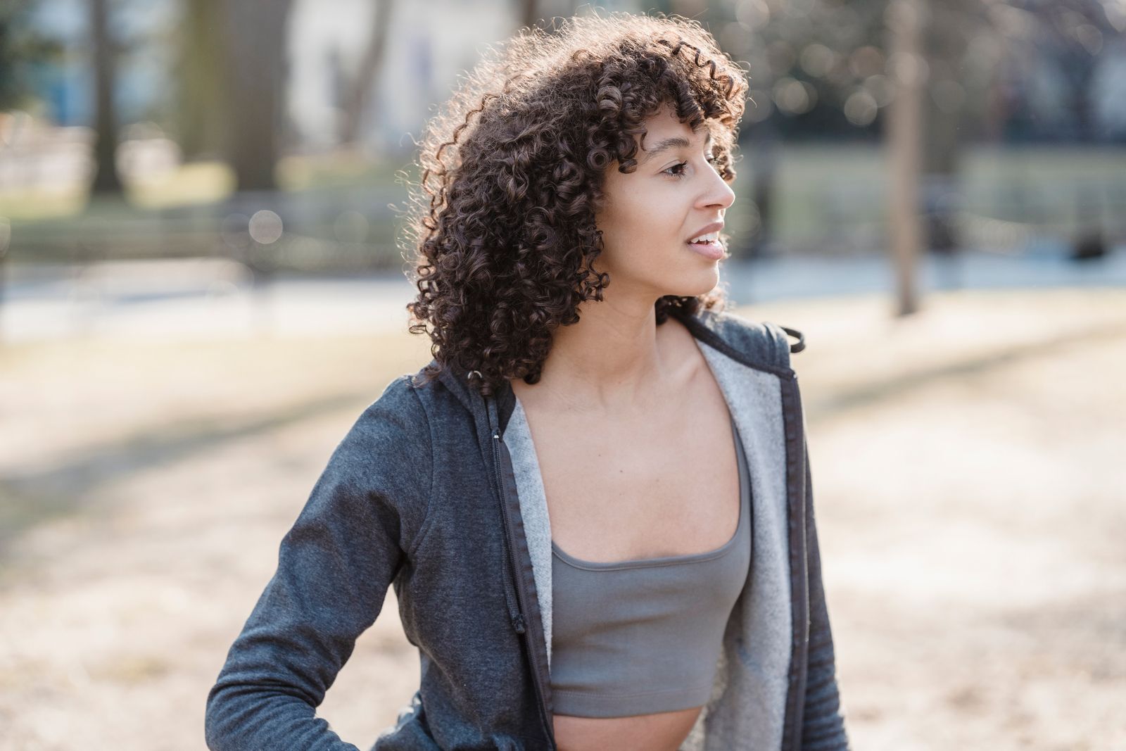 Portrait of African American female in sport outfit looking away on blurred background