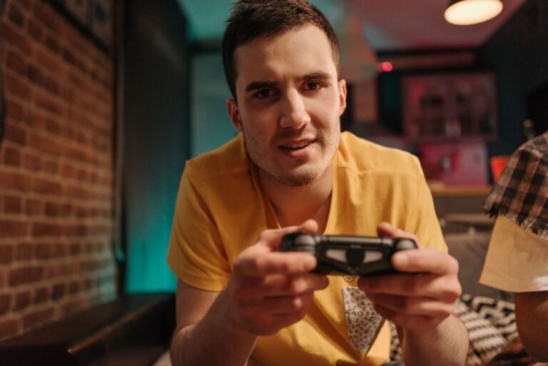 Focused young man enjoying video games with a controller indoors.