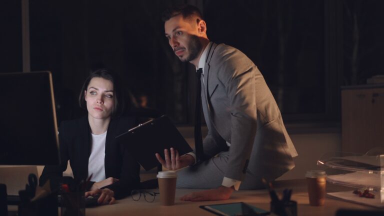 Two colleagues working late in a dimly lit office