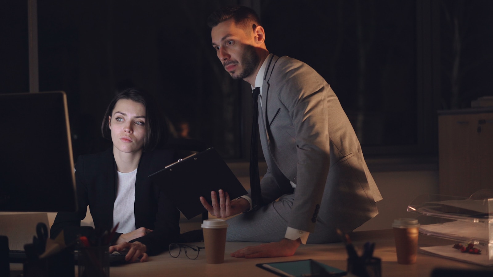 Two colleagues working late in a dimly lit office