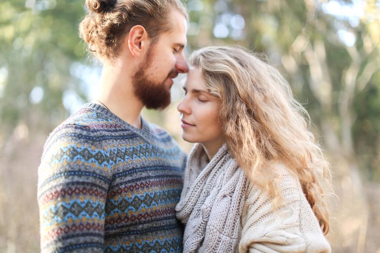 A warm and intimate moment between a couple in a serene outdoor setting, showcasing love and affection.