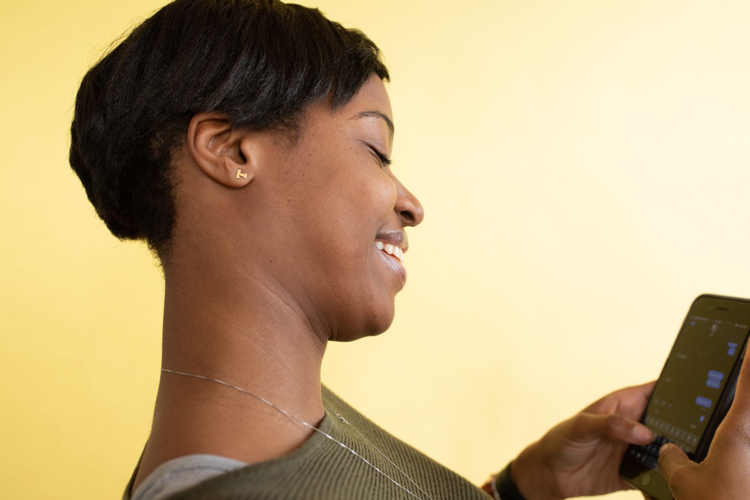 A woman smiling privately while texting on her phone, illustrating the pull of a hidden AI companion conversation