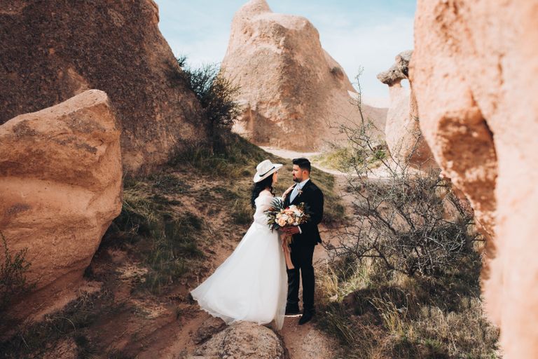 Bride and groom embracing in a picturesque canyon setting, capturing a beautiful moment.
