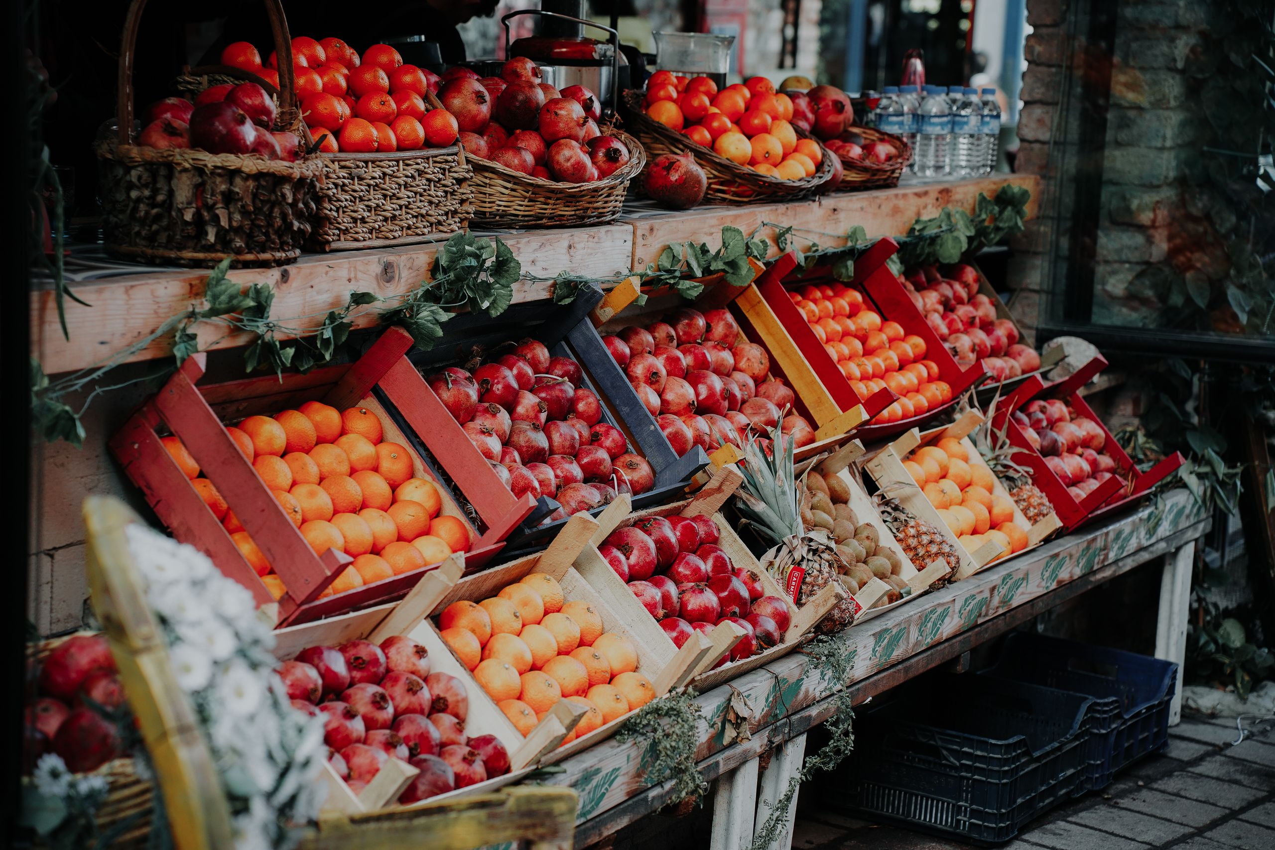Colorful display of assorted fruits neatly arranged in wooden crates at an outdoor market.