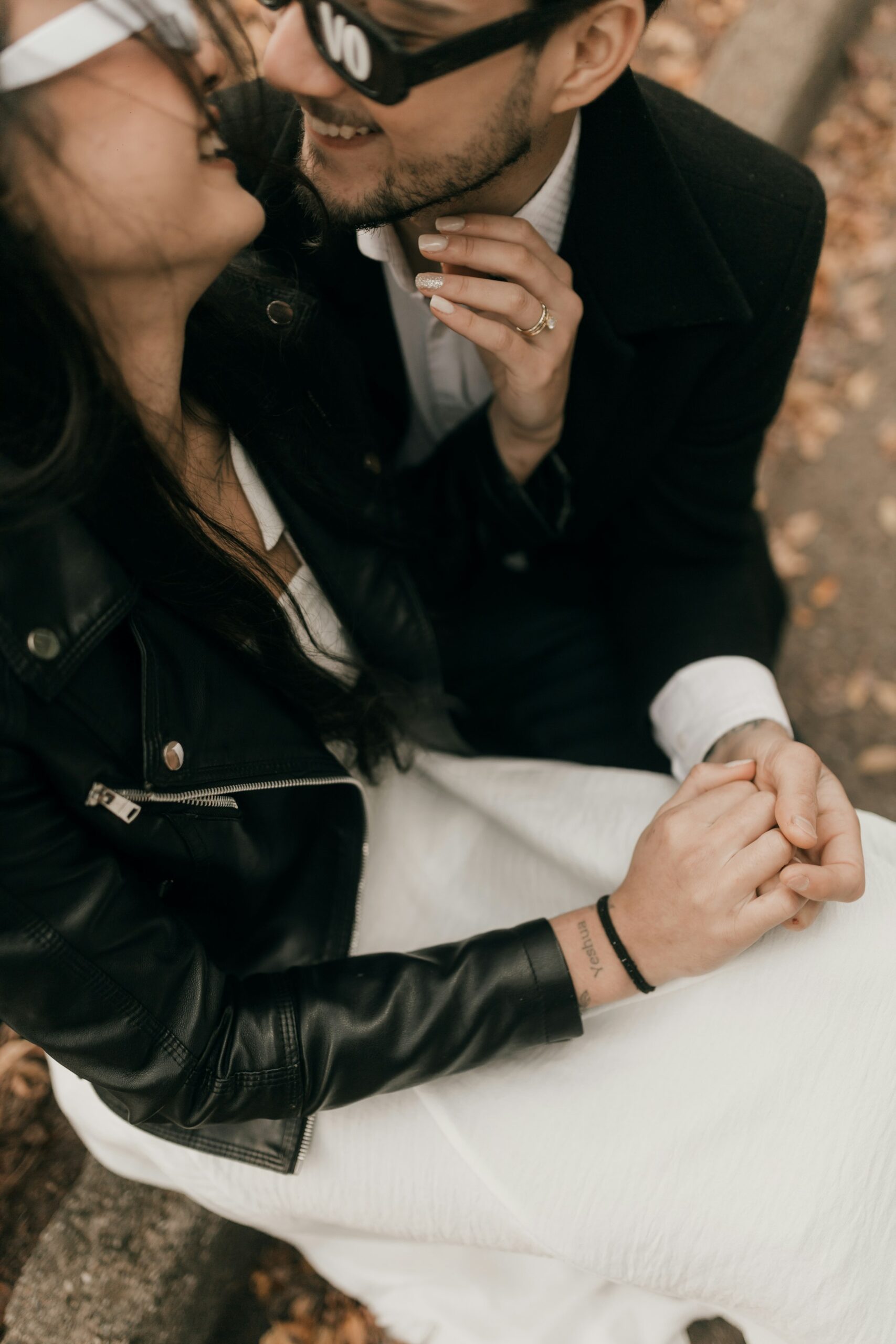 Couple holding hands and smiling happily together in natural light