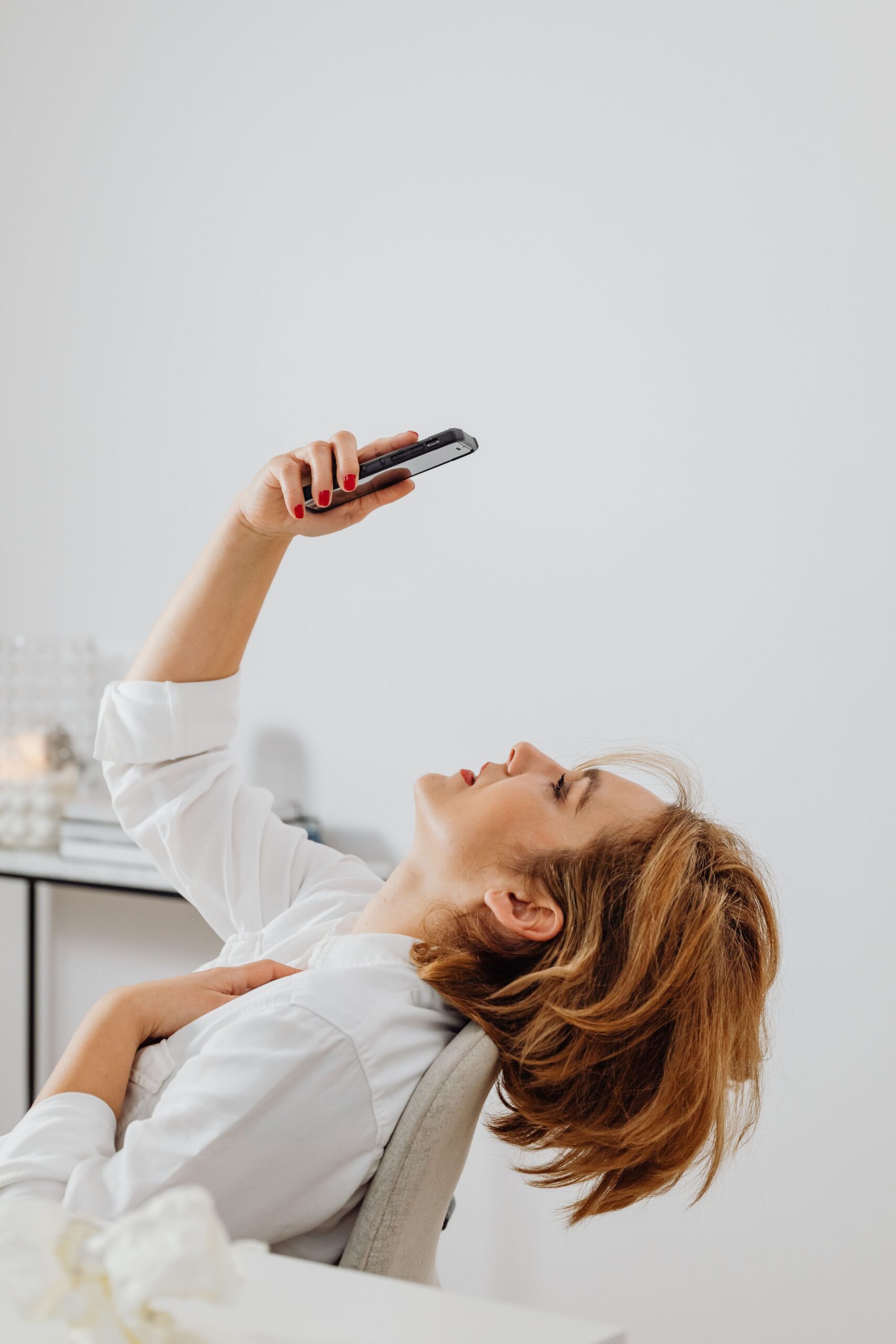 A woman scrolls through her phone with a tired, unenthused expression, reflecting dating app fatigue.
