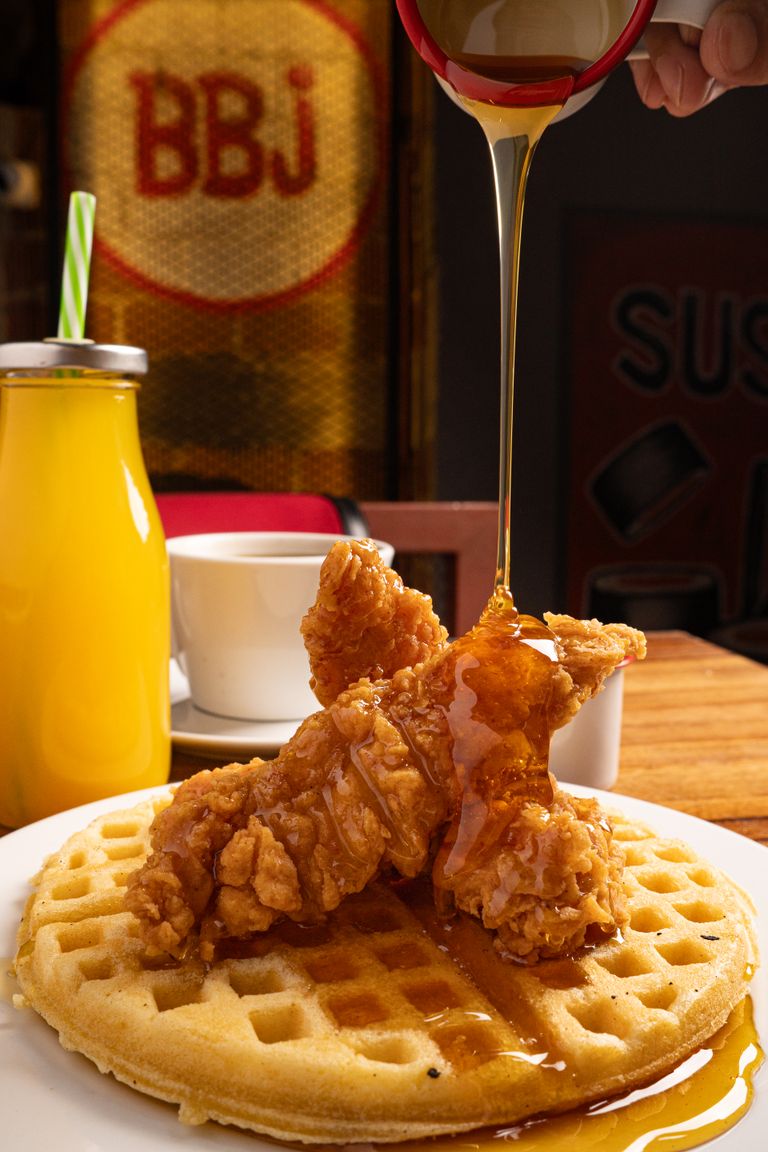 Delicious chicken and waffles drizzled with maple syrup, perfect for breakfast or brunch.