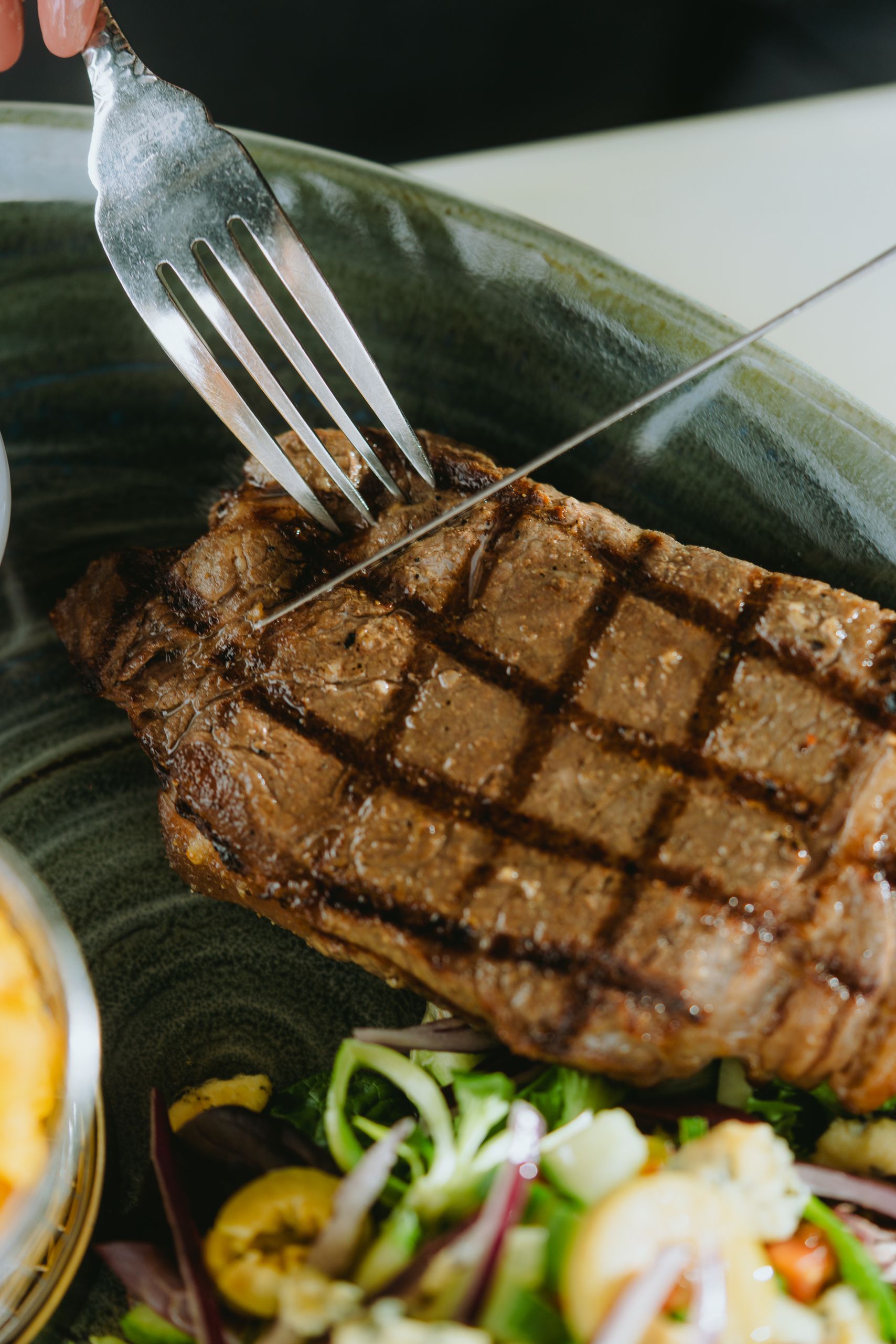 Delicious grilled steak with salad, showcasing a perfect dinner setting.
