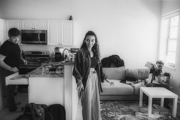 a black and white photo of a woman standing in a kitchen