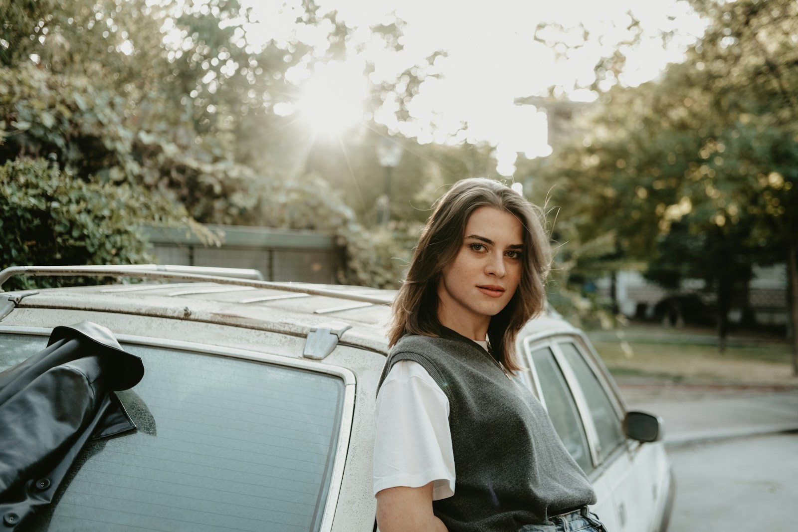 a woman standing next to a parked car