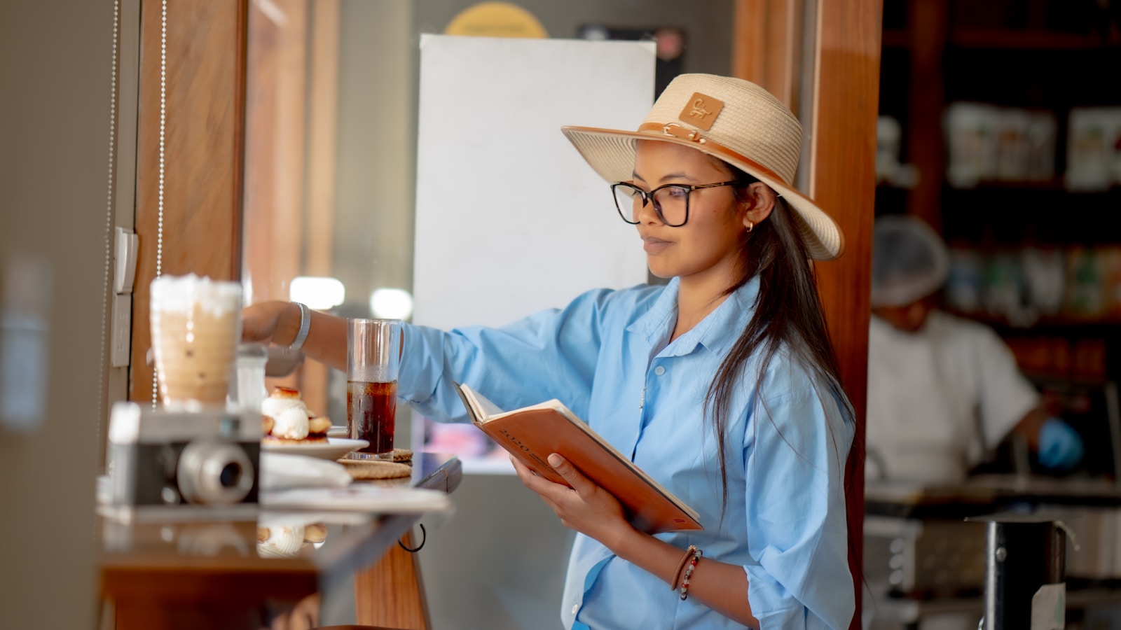 A woman wearing a hat and reading a book