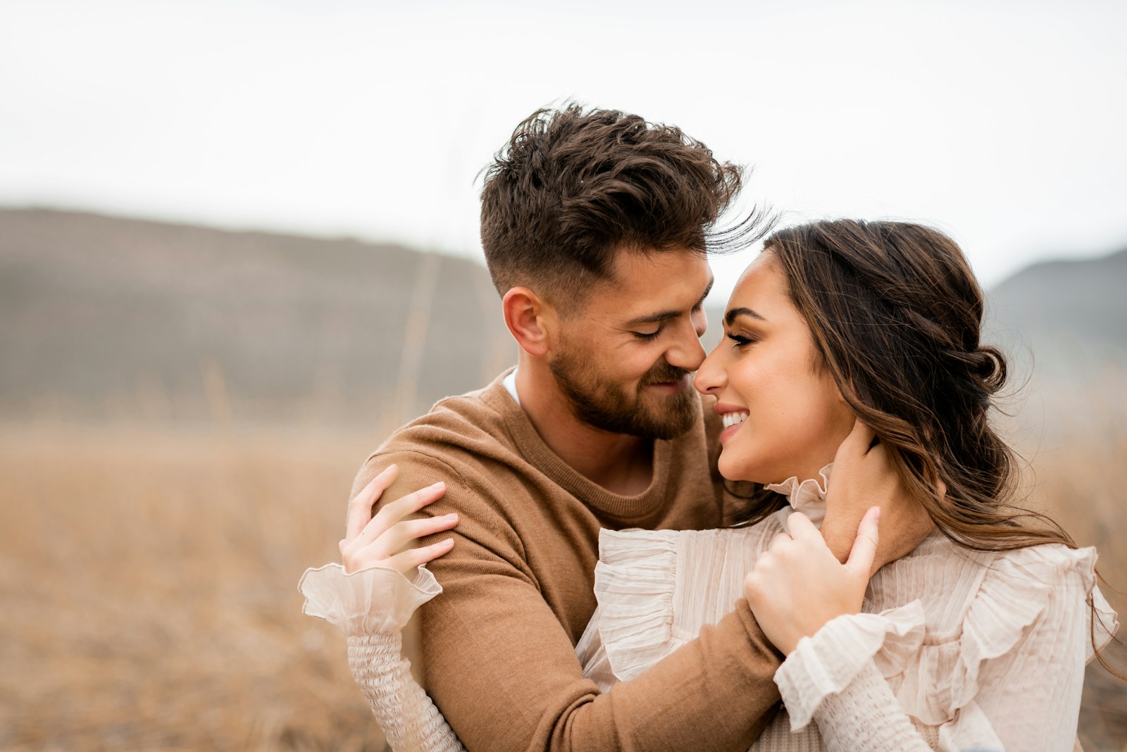 A loving couple embraces and smiles at each other