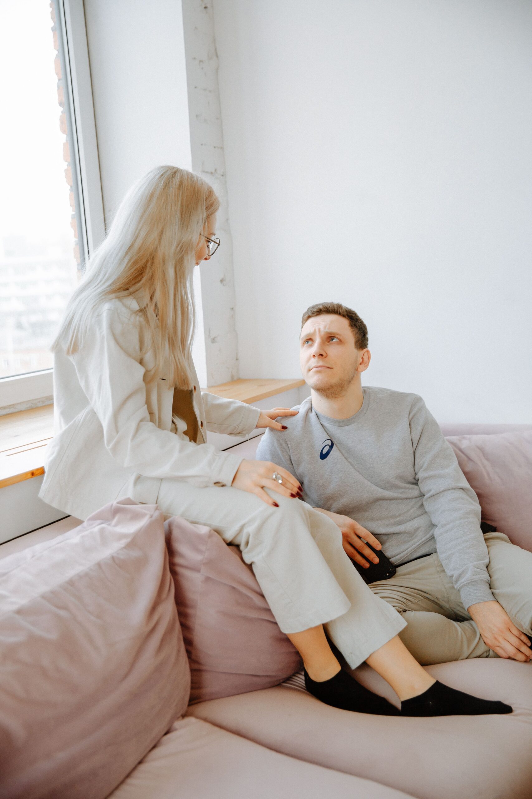 A couple sitting close together on a couch, engaged in a warm, attentive conversation
