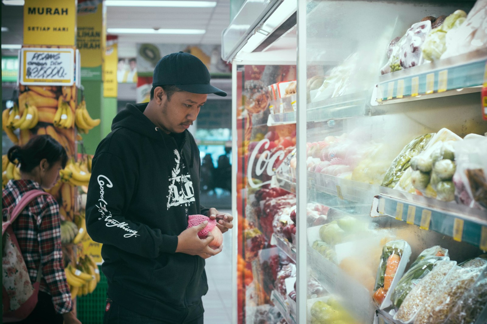 Man in cap shopping for groceries in a supermarket.