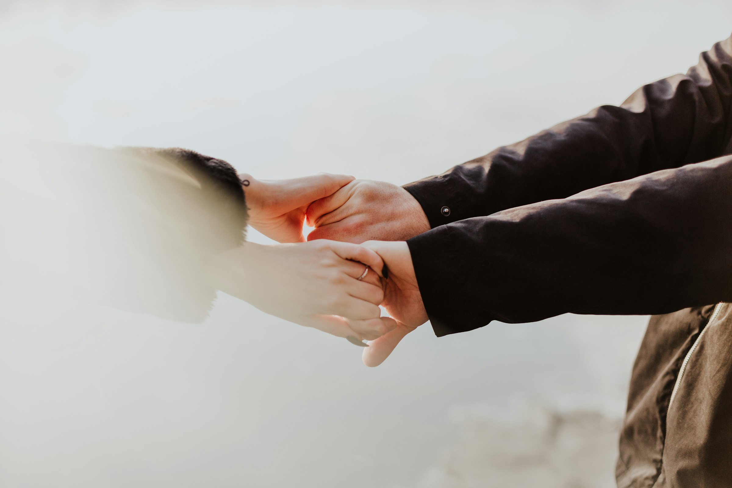 Close-up of a couple holding hands together, symbolizing marriage and commitment
