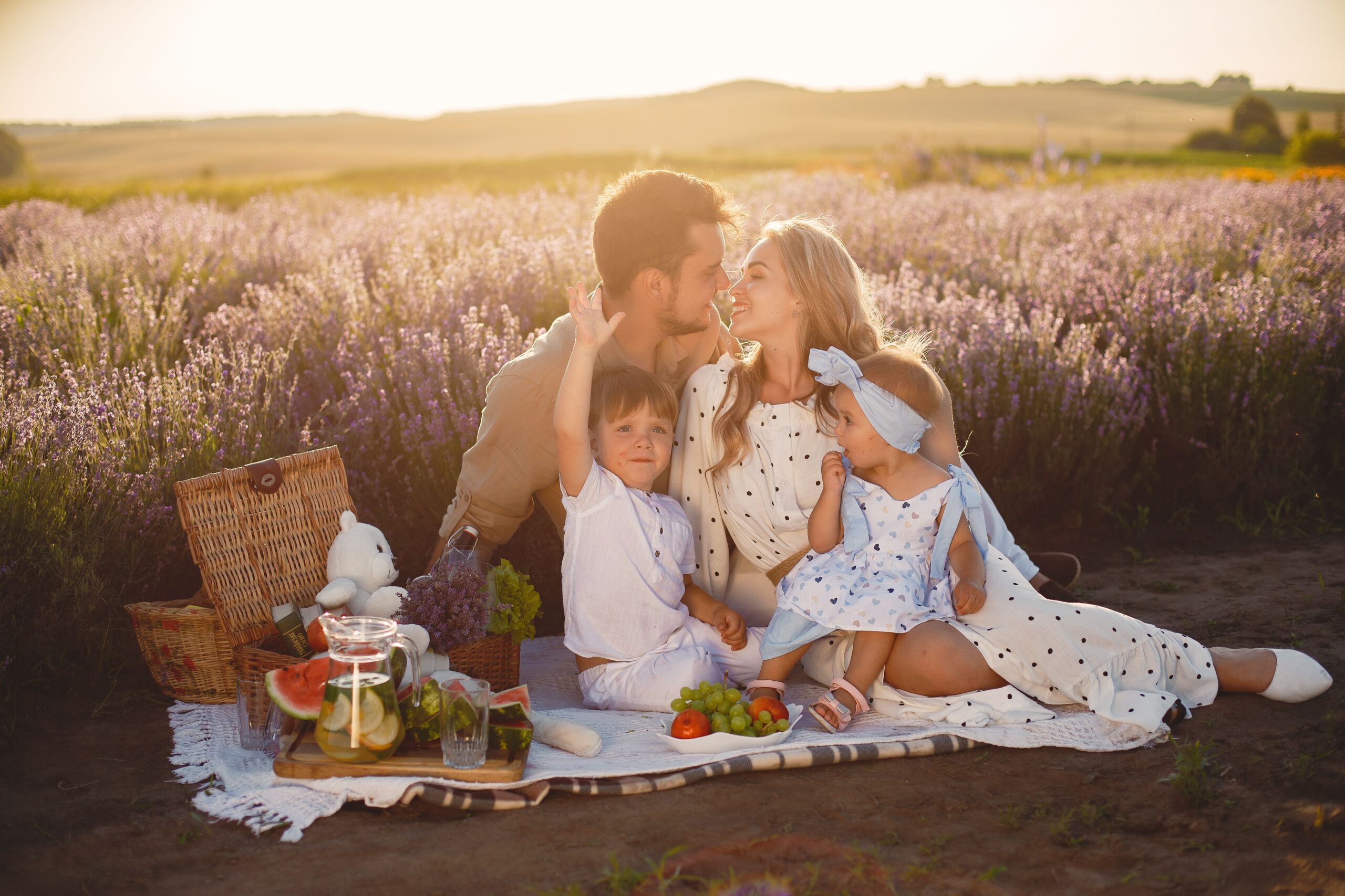A family with young children relaxing together in a lavender field at sunset