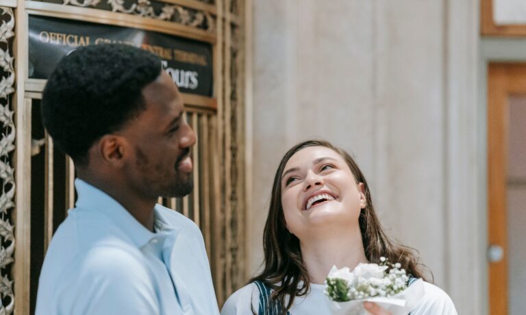 A couple laughing together in warm natural light, sharing a genuinely joyful moment