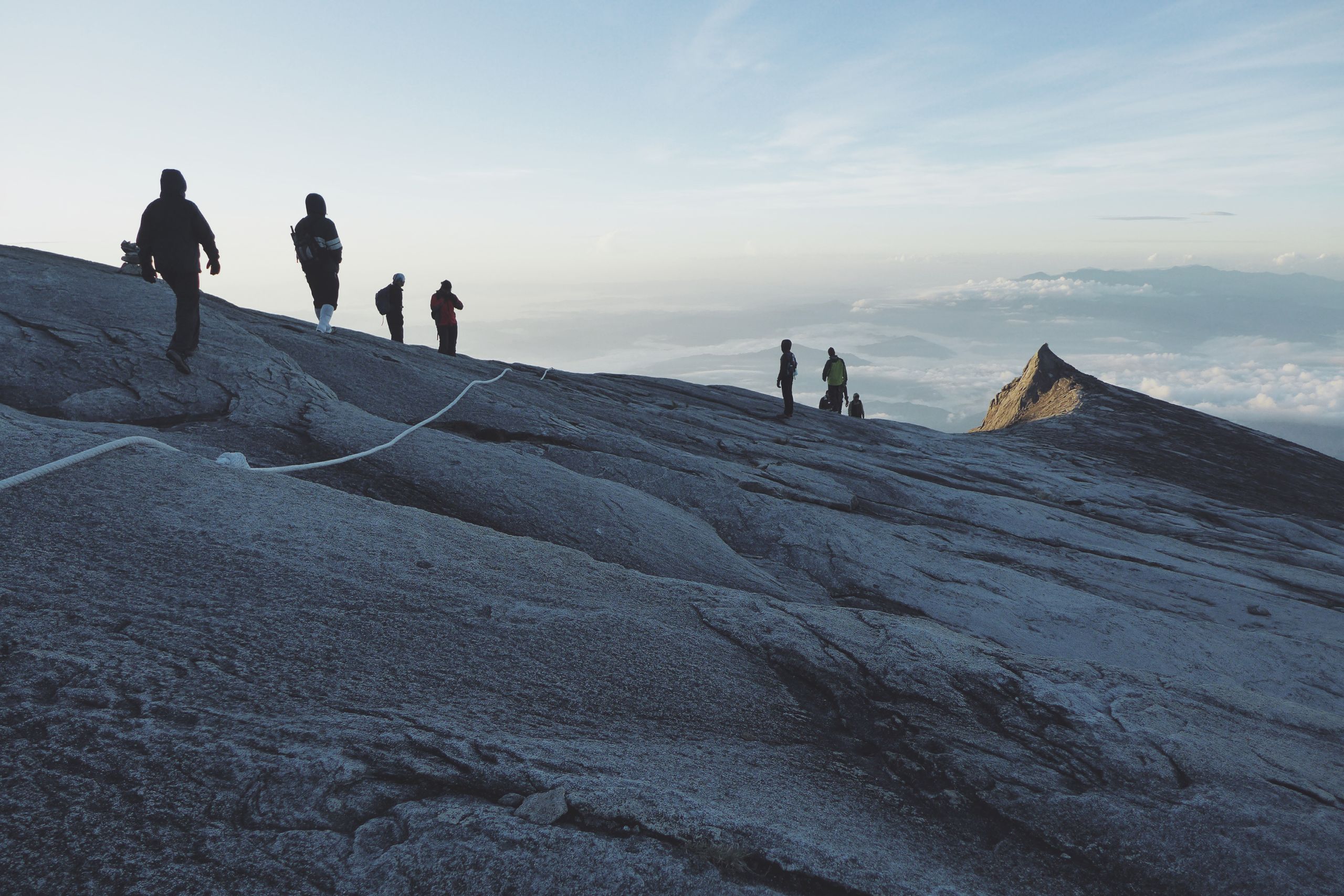 Mount Kinabalu hikers journey towards the peak at dawn amidst stunning cloudscape