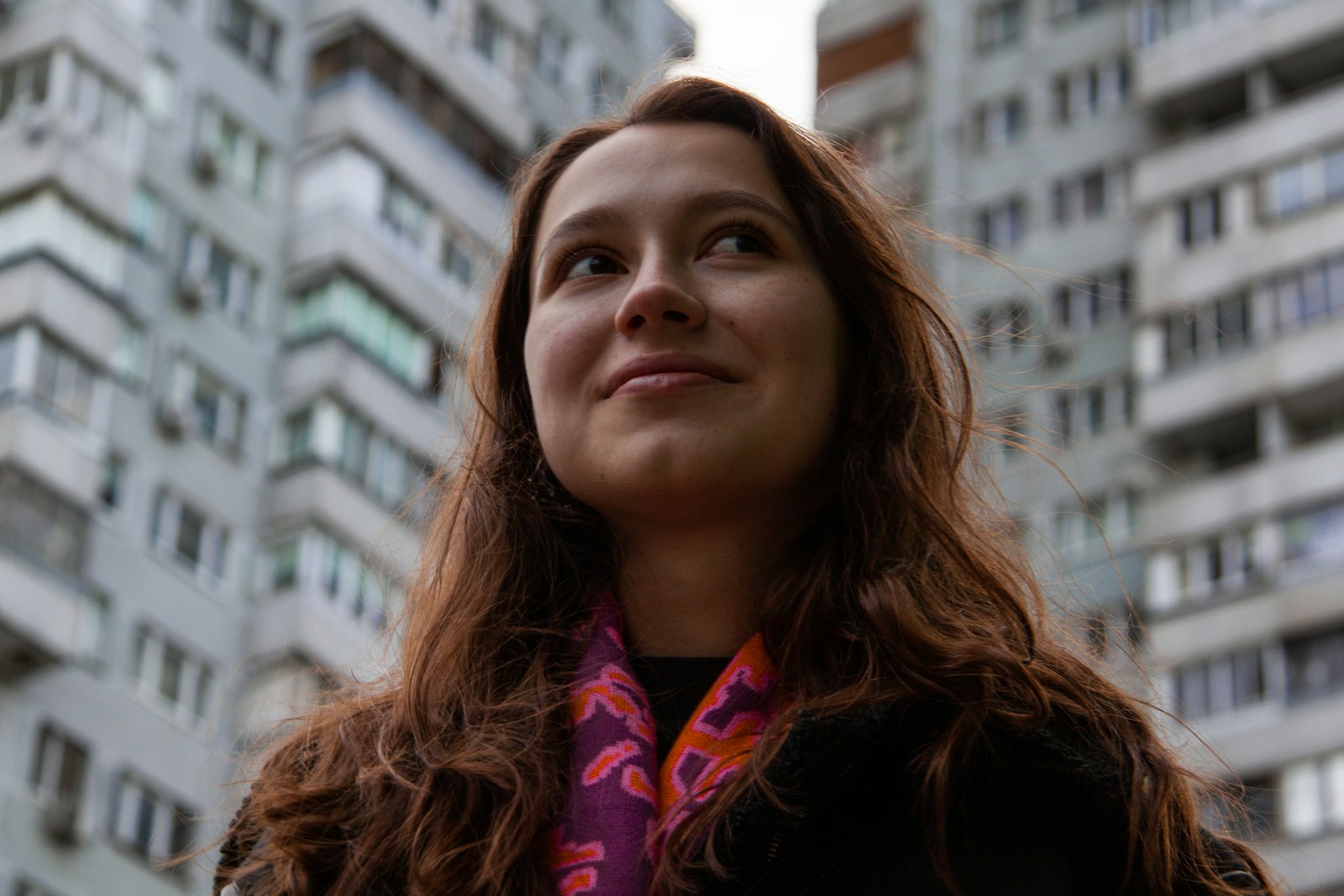 a woman standing in front of a tall building