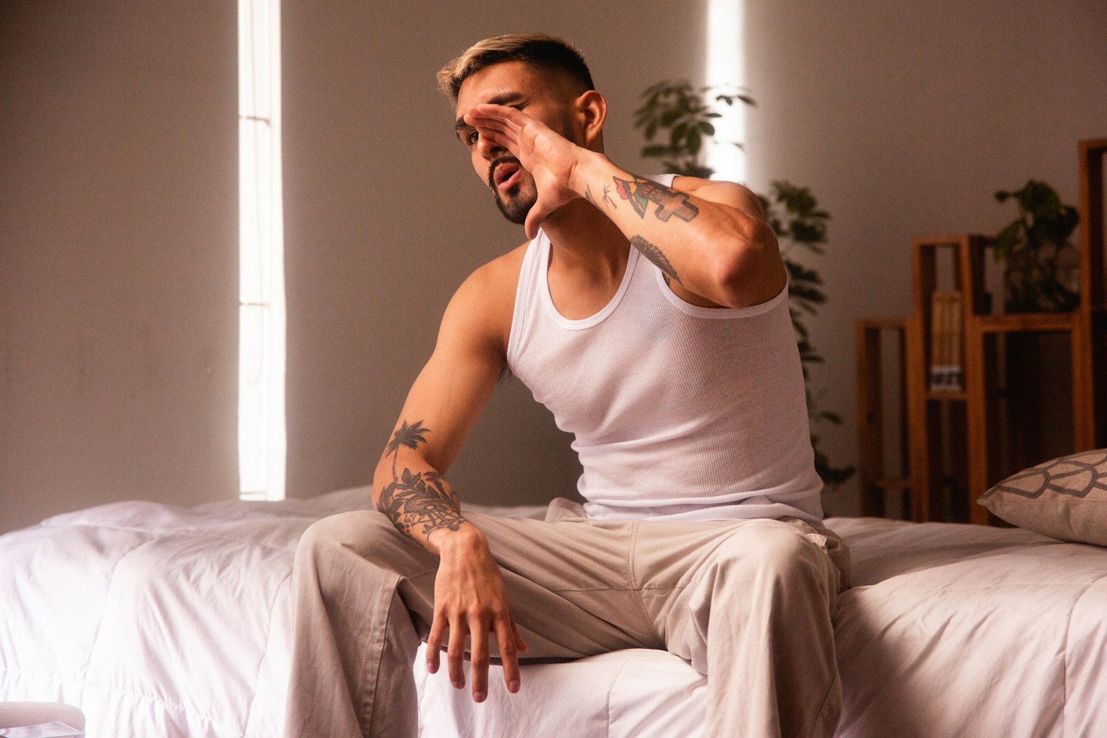 a man sitting on top of a bed in a room