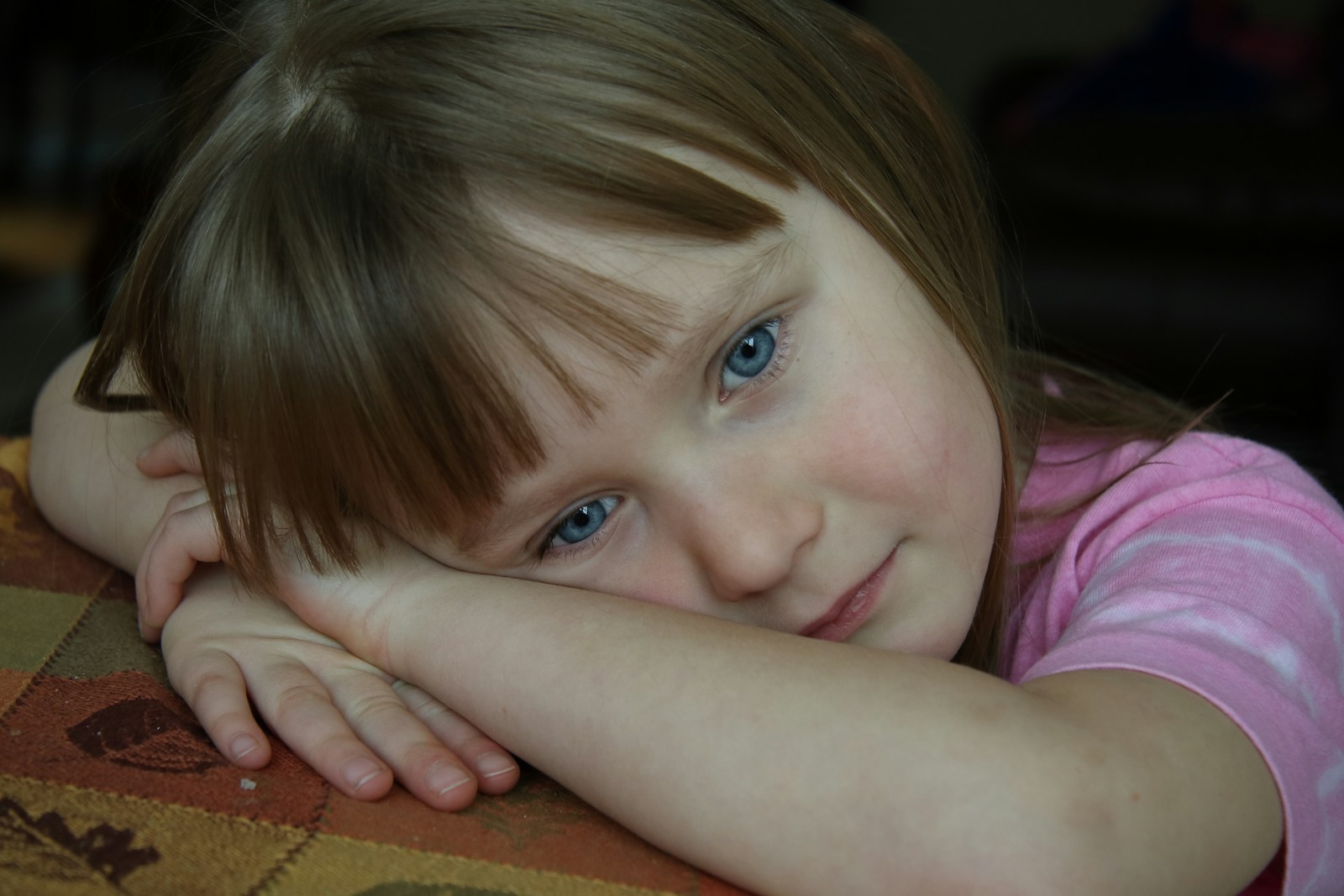 Young girl with blue eyes rests her head