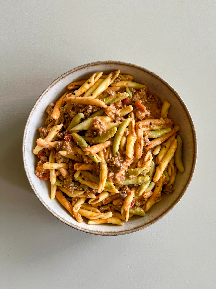 A bowl of colorful pasta with meat sauce