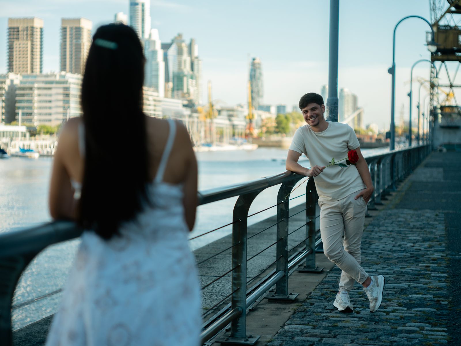 A man offers a rose to a woman by the water in Buenos Aires.