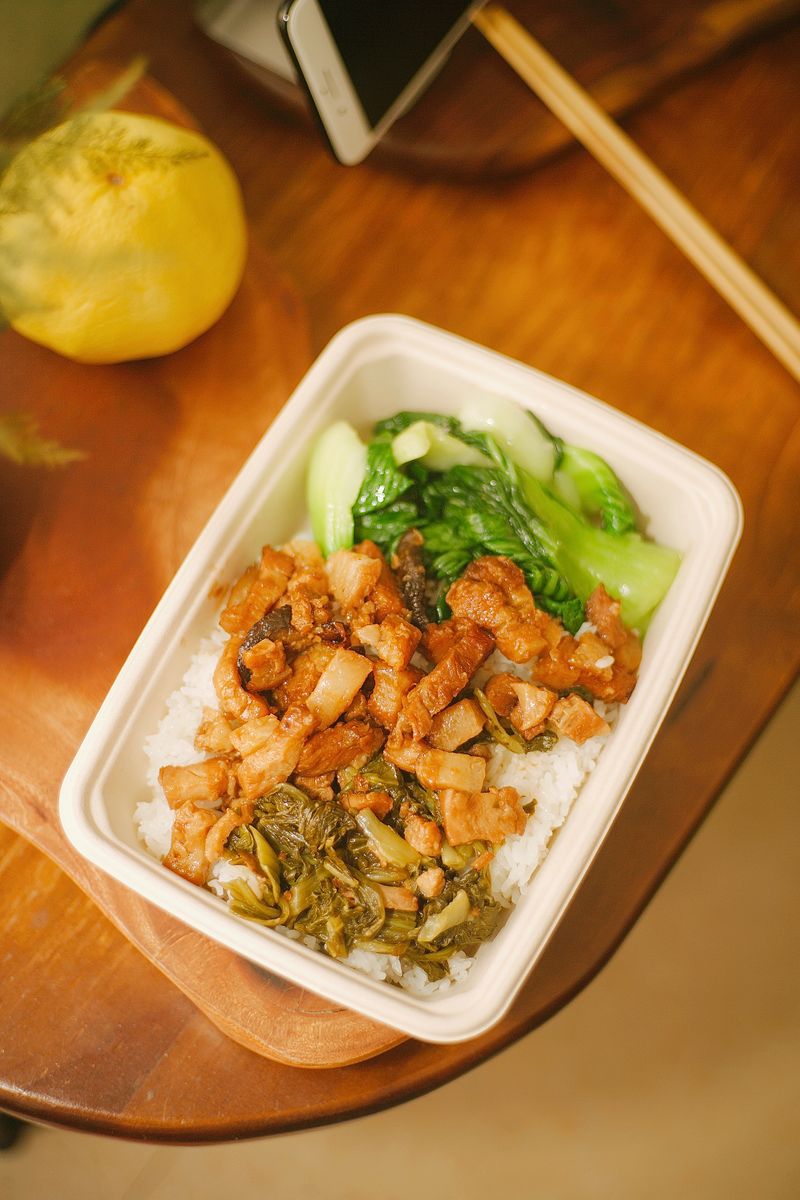 Savor a tasty Asian rice bowl with seasoned pork, fresh greens, and rice.