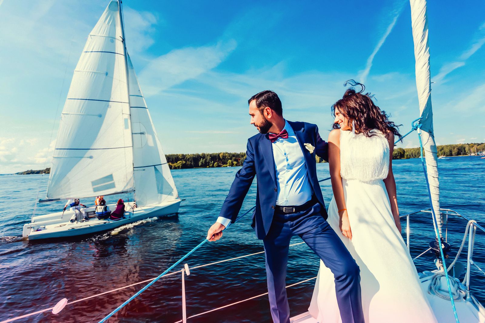 Captivating photo of a bride and groom sailing on a yacht, exuding elegance and joy on their special day.