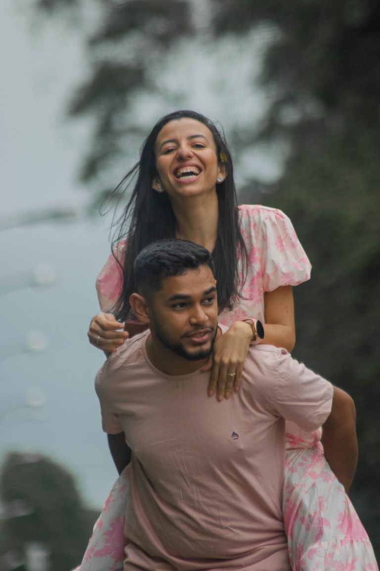 A happy couple enjoying a piggyback ride, showcasing love and fun in an outdoor setting.