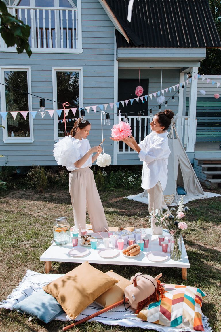 A lively yard party with decorations and friends setting up, perfect for a summer afternoon celebration.