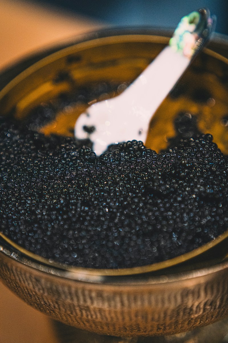 A close-up of black caviar in a golden bowl