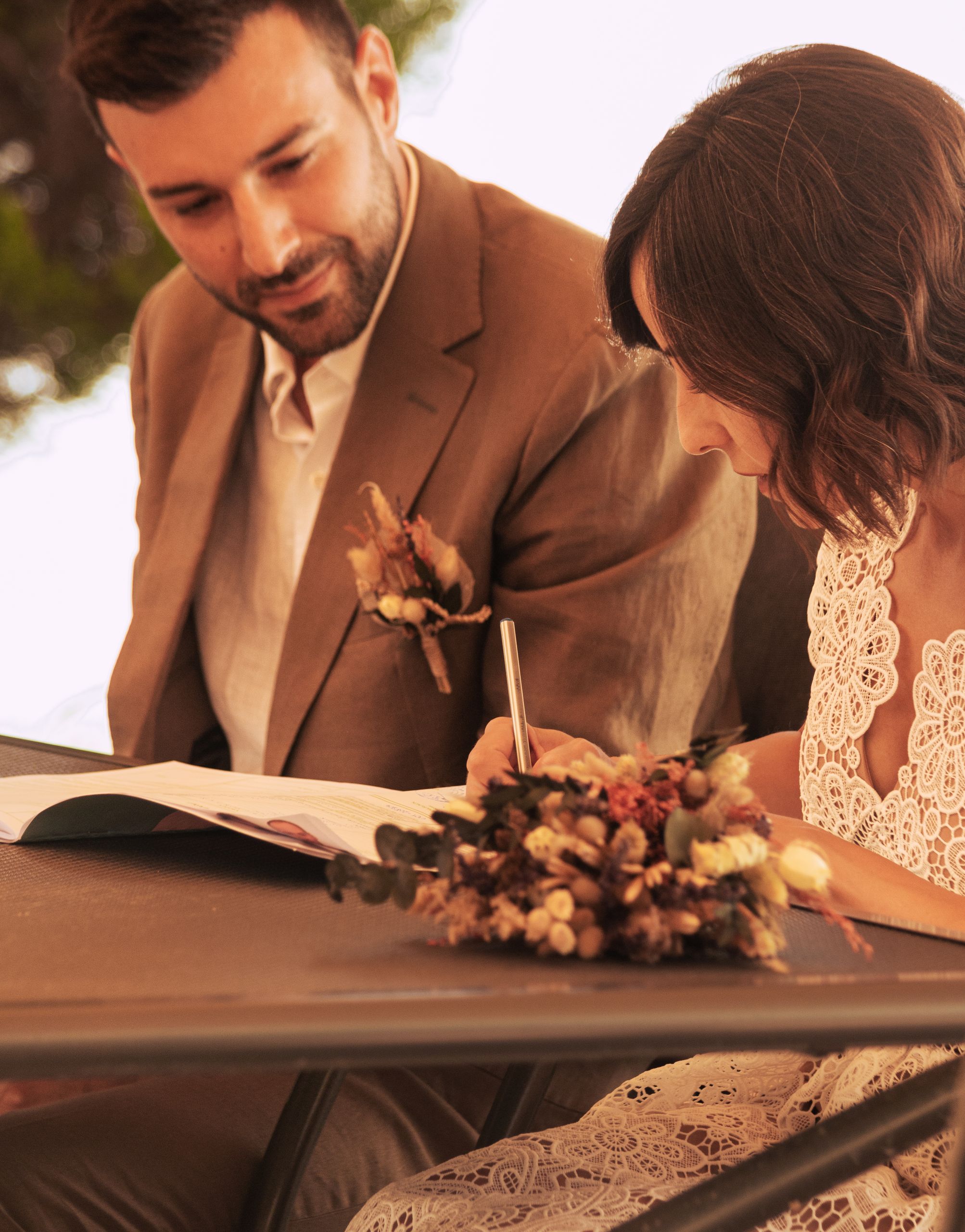 Bride and groom signing documents during their wedding ceremony, elegantly dressed in Tirana, Albania.