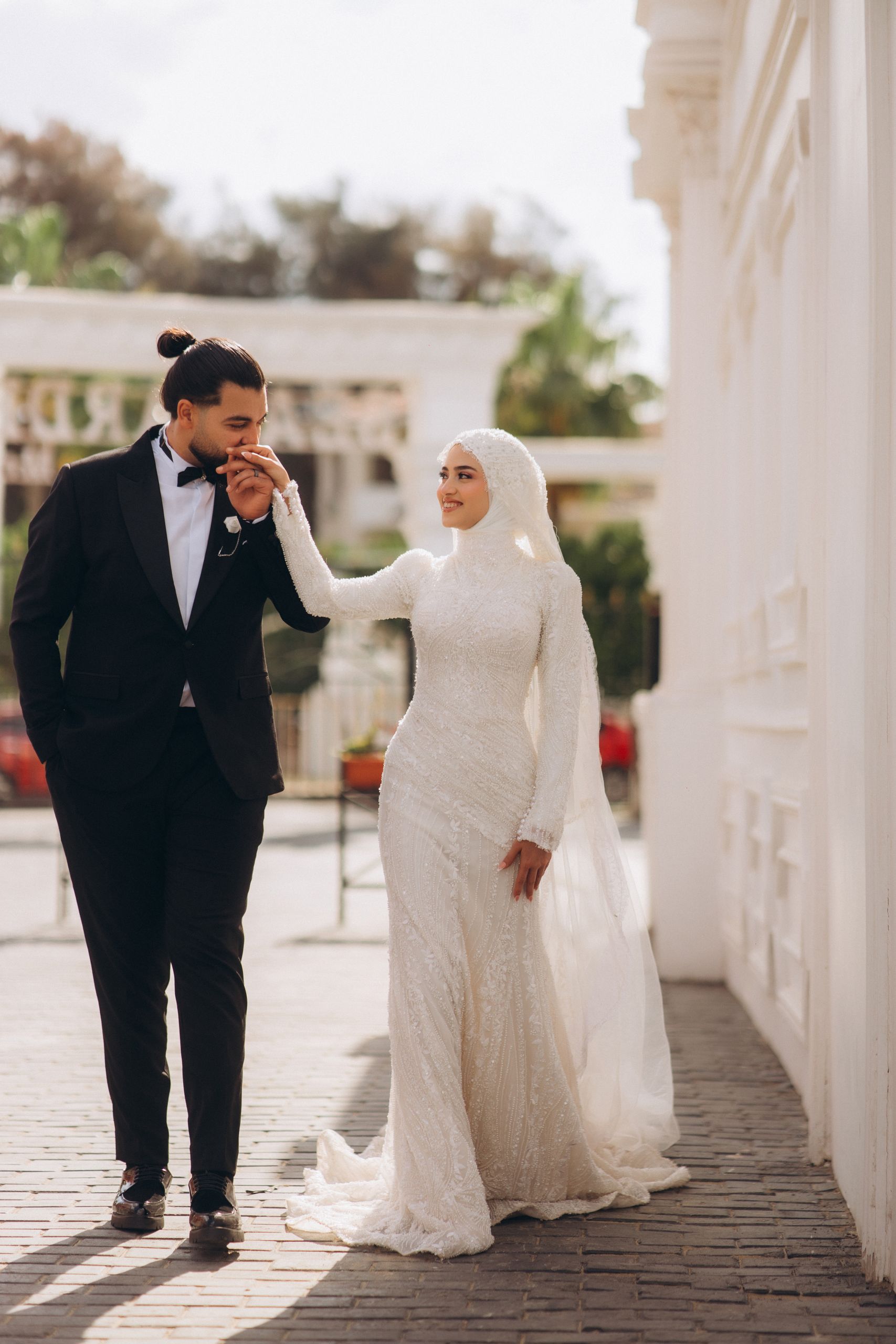 Captured moment of a couple in elegant wedding attire outdoors, symbolizing love and culture.